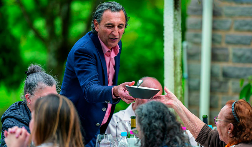 Paulo Geremia alcança um prato para uma senhora